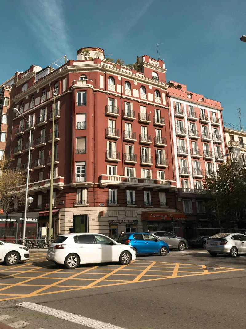 coches aparcados frente a un edificio marrón
